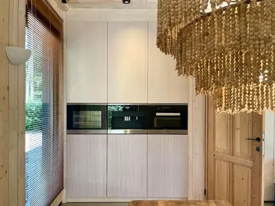 a kitchen with white cabinets and a chandelier at AWolf in a healthy NEW home in Herentals