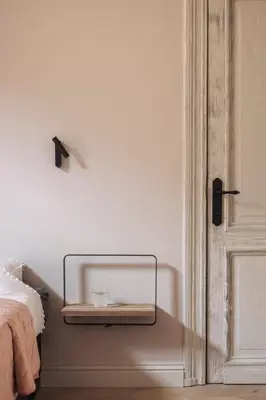 a bedroom with a bed and a shelf next to a door at Zurenborg Suites in Antwerp