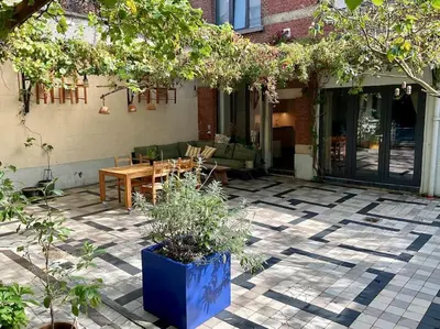a patio with a wooden table and a blue pot at Studio Richard in Antwerp