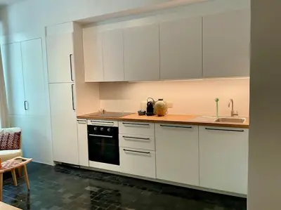 a kitchen with white cabinets and a sink at Studio Richard in Antwerp
