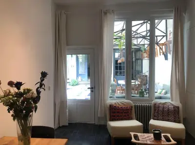 a living room with a door and chairs and a table at Studio Richard in Antwerp