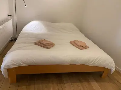 two brown towels sitting on a white bed at Studio Richard in Antwerp