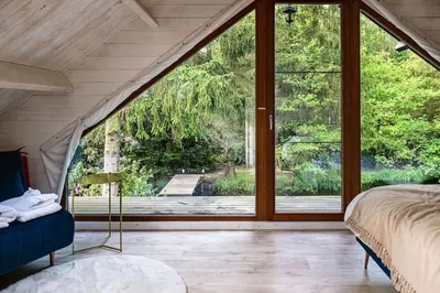 a bedroom with a large glass window and a bed at ZenCabin - Luxe en Wellness in de natuur in Hulshout