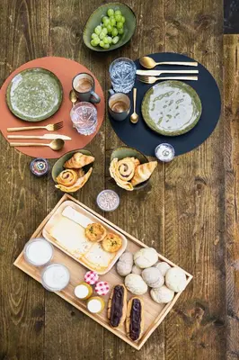 a wooden table with plates of food and snacks at ZenCabin - Luxe en Wellness in de natuur in Hulshout