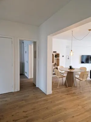 a dining room and living room with a table and chairs at Fully equiped 100 m2 appt with the perfect location in Vilvoorde