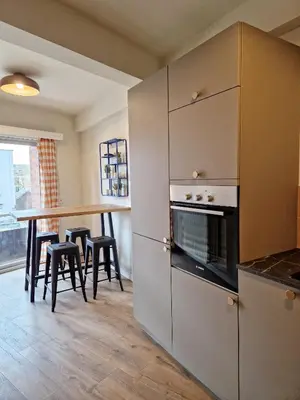 a kitchen with a counter and a table with stools at Fully equiped 100 m2 appt with the perfect location in Vilvoorde