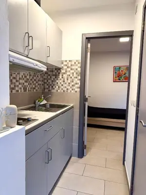 a kitchen with white cabinets and a sink at Studio situé à Woluwe-Saint-lambert in Brussels