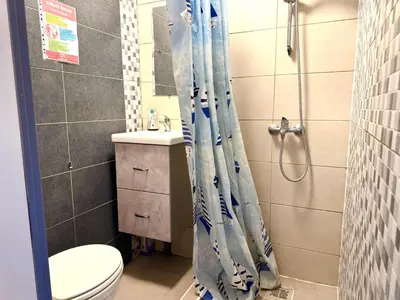 a bathroom with a toilet and a shower curtain at Studio situé à Woluwe-Saint-lambert in Brussels