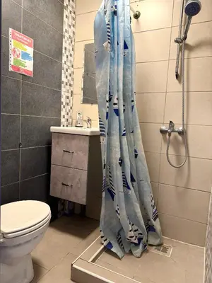 a shower curtain in a bathroom with a toilet at Studio situé à Woluwe-Saint-lambert in Brussels