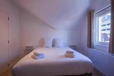 a bedroom with a white bed with towels on it at Märch - Mechelen Goat 14 in Mechelen