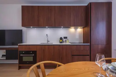 a kitchen with wooden cabinets and a table with wine glasses at Märch - Mechelen Goat 14 in Mechelen