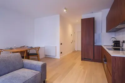a living room with a couch and a kitchen with a table at Märch - Mechelen Goat 14 in Mechelen