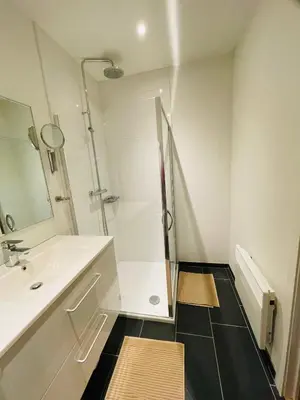 a white bathroom with a shower and a sink at Studio Intensity in Antwerp