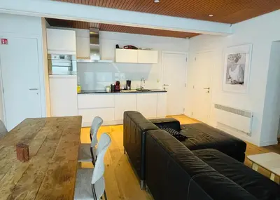 a living room with a couch and a table and a kitchen at Studio Intensity in Antwerp
