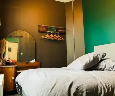 a bedroom with a bed and a mirror and a sink at Living History - Suikernest in Antwerp