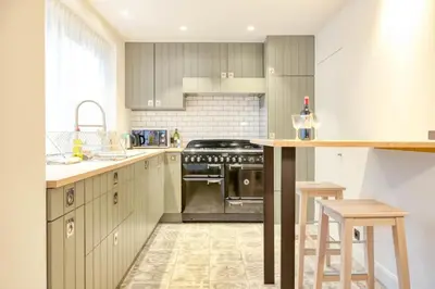 a kitchen with wooden cabinets and a stove top oven at Chic 3-BR Oasis in Ghent - Stylish Interiors in Ghent
