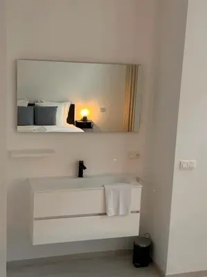 a white bathroom with a mirror and a sink at Wonderful central 2BR Ghent apt w view on Leie in Ghent