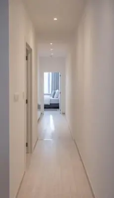 an empty hallway with a white room with a couch at Wonderful central 2BR Ghent apt w view on Leie in Ghent