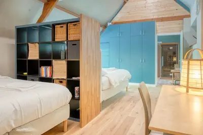 a bedroom with a bed and a desk and a table at Cozy Retreat with Sauna near Gent-St-Pieters in Ghent