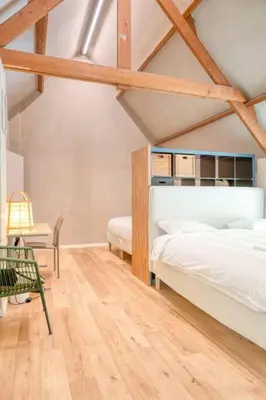 a bedroom with two beds and a chair at Cozy Retreat with Sauna near Gent-St-Pieters in Ghent