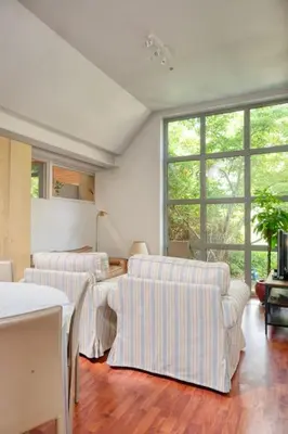 a living room with two white chairs and a table at Cozy Retreat with Sauna near Gent-St-Pieters in Ghent
