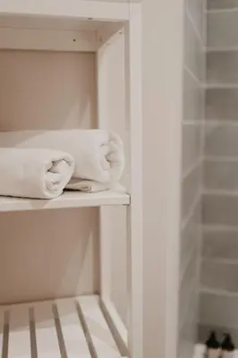 a bathroom with white towels on a shelf at Modern home near Ghent - Easy Access, Ideal Living in Ghent