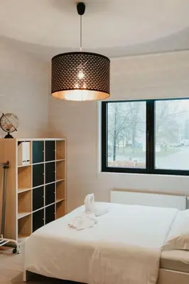 a bedroom with a white bed and a large window at Modern home near Ghent - Easy Access, Ideal Living in Ghent