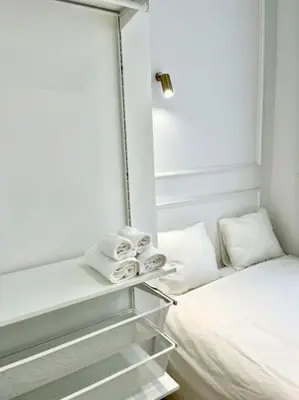 a small room with a bed and a mirror at Chez Gianni & Stéphanie - A cozy and elegant Studio in Brussels in Brussels