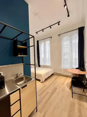 a kitchen with a sink and a bed in a room at Chez Gianni & Stéphanie - A cozy and elegant Studio in Brussels in Brussels