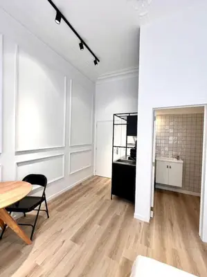 a white room with a table and a chair at Chez Gianni & Stéphanie - A cozy and elegant Studio in Brussels in Brussels