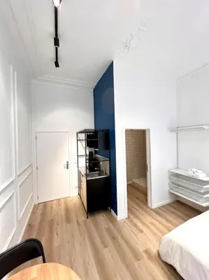 a room with a bed and a table in it at Chez Gianni & Stéphanie - A cozy and elegant Studio in Brussels in Brussels
