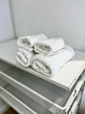 a stack of towels on a shelf in a bathroom at Chez Gianni & Stéphanie - A cozy and elegant Studio in Brussels in Brussels