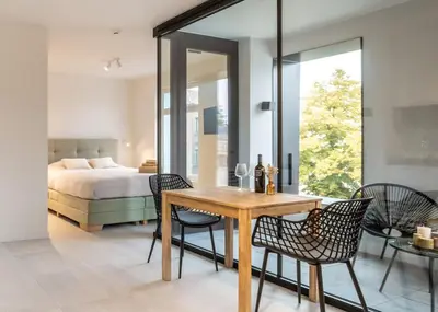 a bedroom with a bed and a table and chairs at Mavue kamer met terras in Mechelen