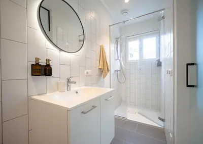 a white bathroom with a sink and a shower at Mavue kamer met terras in Mechelen