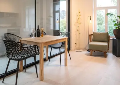 a dining room with a wooden table and chairs at Mavue kamer met terras in Mechelen