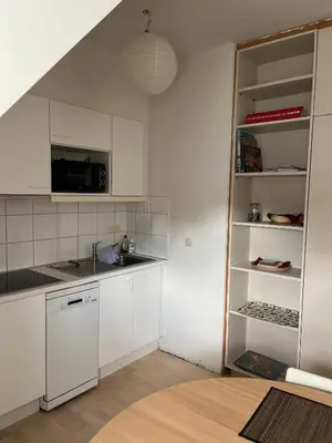 a kitchen with white cabinets and a sink at Studio Tintin in Brussels