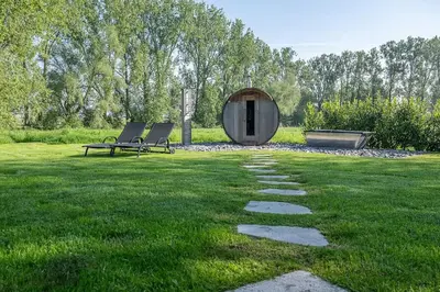 two chairs and a circular building in a grass field at Cozy 4-Bedroom Chalet with Outdoor Spa in Zottegem in Zottegem