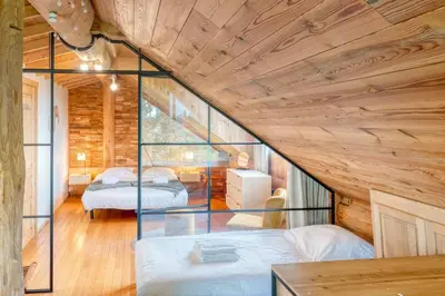 a room with two beds and a glass wall at Cozy 4-Bedroom Chalet with Outdoor Spa in Zottegem in Zottegem