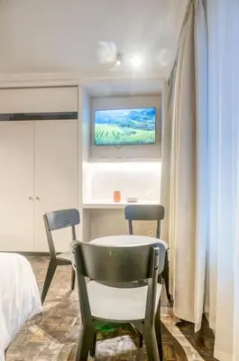 a bedroom with two chairs and a table and a tv at Chic 3P Retreat in Heart of Ghent in Ghent