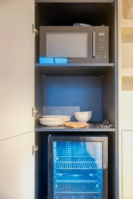 a kitchen with a microwave and dishes on shelves at Chic 3P Retreat in Heart of Ghent in Ghent