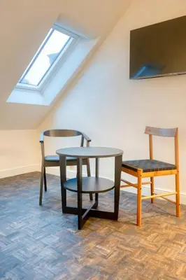 a table and chairs in a room with a skylight at Charming Attic Studio in Ghent in Ghent