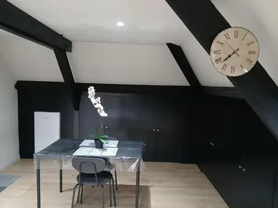 a dining room with a table and a clock on the ceiling at Flat at Relegem in Asse
