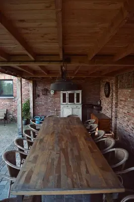a large wooden table in a room with chairs at Vakantiewoning de Huismus in Oud-Turnhout