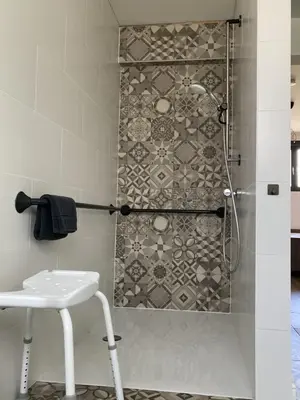 a shower with a glass door and a stool in a bathroom at Vakantiewoning de Huismus in Oud-Turnhout