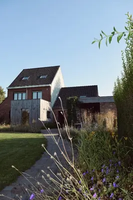 a large brick house with a roof at Vakantiewoning de Huismus in Oud-Turnhout