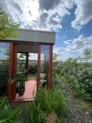 a small house with a deck in a garden at Studio Conda in Antwerp