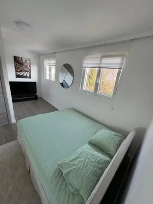 a bedroom with a green bed in a white room at Qozyroom in Brussels