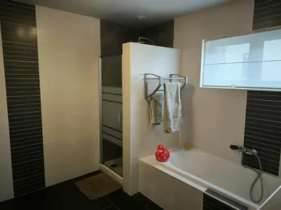 a bathroom with a bath tub and a shower at Vakantiewoning De Zilverberk in Geraardsbergen