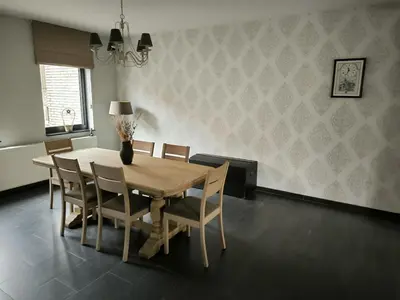 a dining room with a wooden table and chairs at Vakantiewoning De Zilverberk in Geraardsbergen