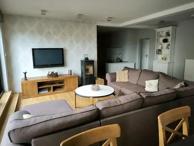 a living room with a couch and a tv at Vakantiewoning De Zilverberk in Geraardsbergen